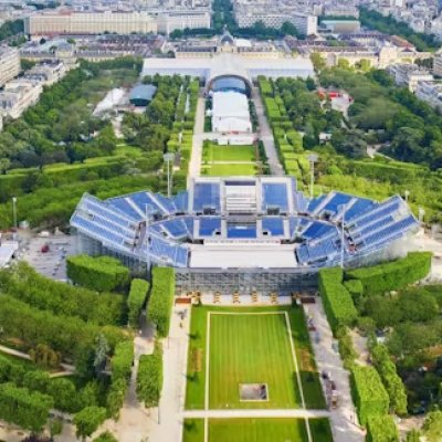 an aerial view of a stadium with raised seating surrounded by green parkland